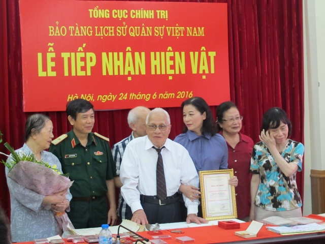 Thiếu tướng Nguyễn Xuân Năng, Giám đốc Bảo tàng LSQS VN tiếp nhận hiện vật do Đại tá Đào Văn Trường và gia đình trao tặng.