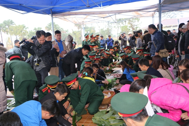 Đồng bào, thanh niên và các chiến sĩ trường Sĩ quan Lục quân 1 tham gia gói bánh chưng xanh