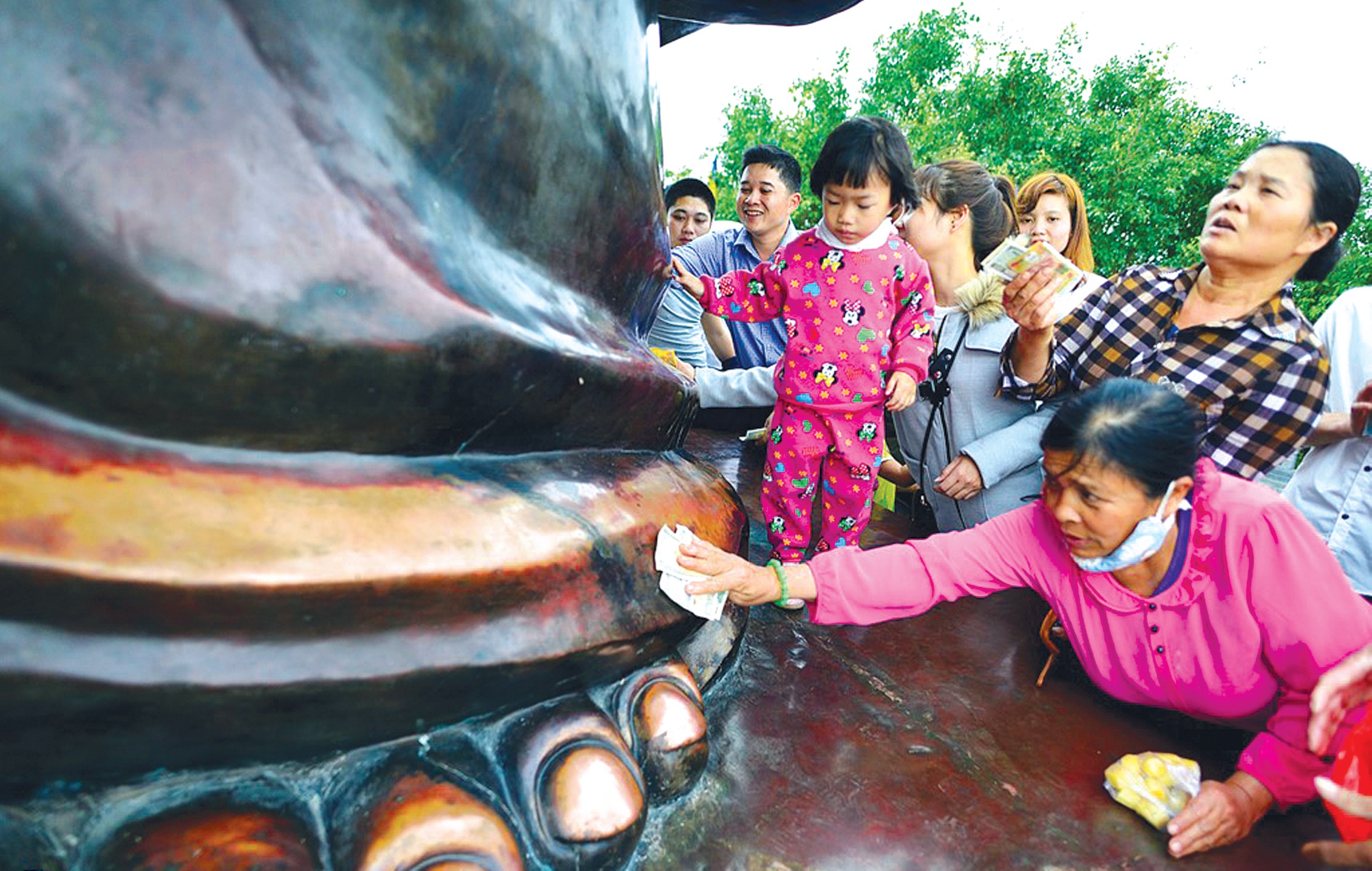 Xoa tiền lên tượng Phật ở Chùa Bái Đính