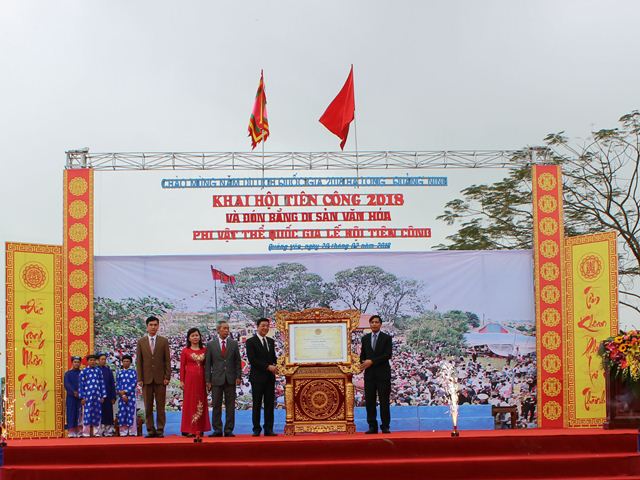 Đồng chí Vũ Văn Diện (bên phải) đại diện cho Cục di sản Văn Hóa trao bằng di sản phi vật thể Quốc gia Lễ hội Tiên Công cho chính quyền nhân dân thị xã Quảng Yên