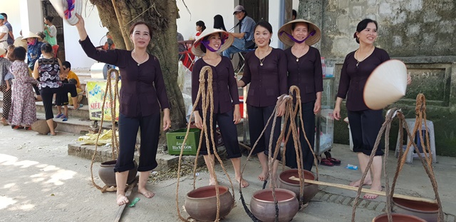 Phụ nữ trong đội nghi lễ chuẩn gánh nước đổ vào sới vật.