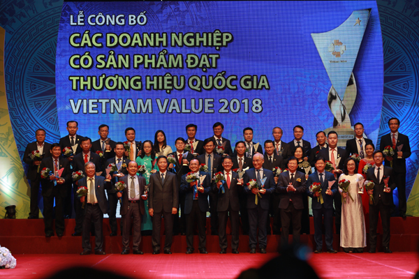 Phó Thủ tướng Chính phủ Trịnh Đình Dũng và Bộ trưởng Bộ Công Thương Trần Tuấn Anh với các doanh nghiệp tại lễ công bố năm 2018