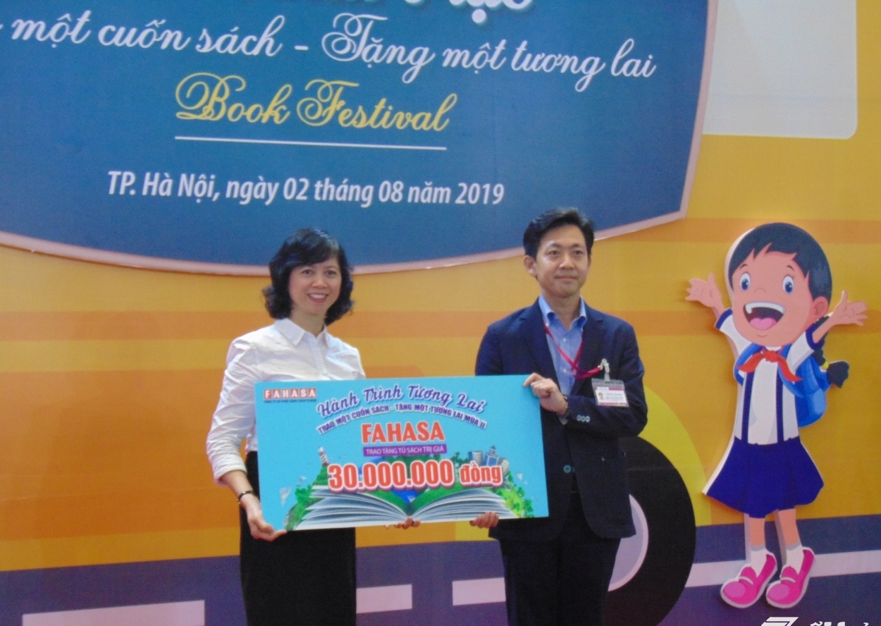 Bà Phạm Thị Hóa và đại diện lãnh đạo Trung tâm thương mại Aeon Mall Long Biên trao tặng sách cho các em học sinh nghèo tại tỉnh Điện Biên